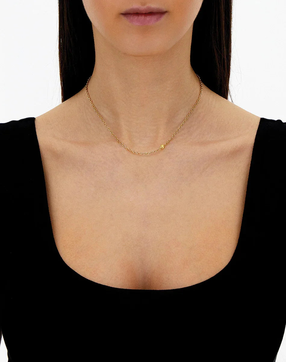 シンプルな金色チェーンネックレスを身につけた女性、ジュエリー展示用