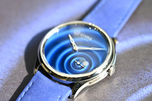 青いグラデーション文字盤とブルーストラップの高級機械式腕時計のクローズアップ