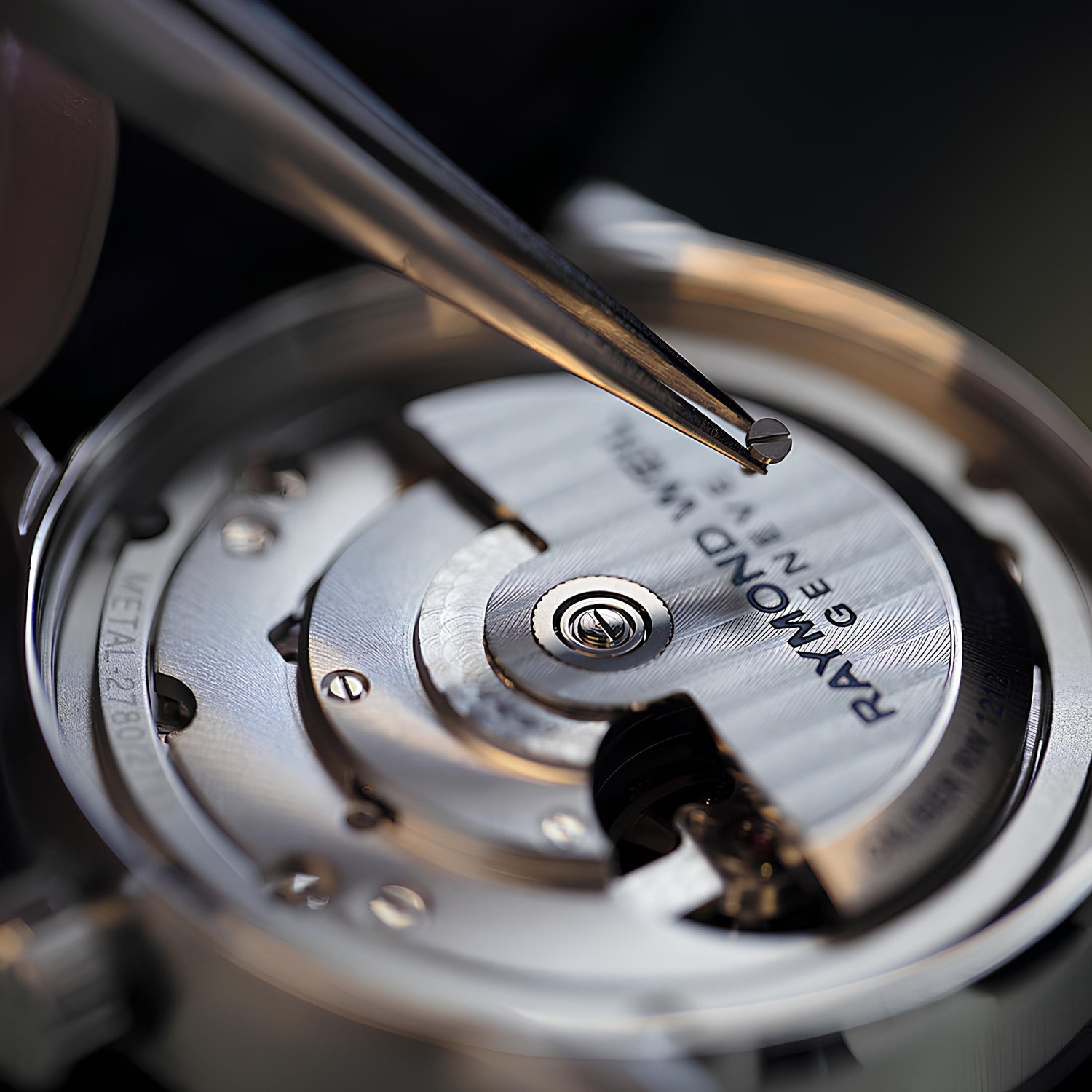 CONTÉVANOU mechanical watch movement close-up with tweezers fitting a part