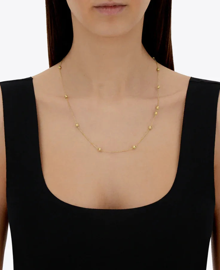 シンプルなゴールドボール付きネックレスを着用した女性、宝飾品アクセサリー